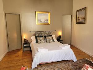 a bedroom with a bed with white sheets and pillows at LA MAITRISE in Bayeux