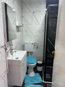 a bathroom with a toilet and a sink and a mirror at Kuman Apartments in Kumanovo