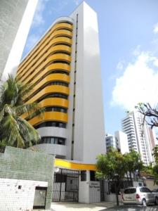 a tall yellow and white building in a city at Residencial em Meireles in Fortaleza