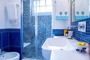 a blue tiled bathroom with a sink and a shower at Capri Villa Vittoria by Capri Property in Anacapri
