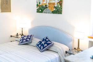 a bedroom with a blue bed with two pillows on it at Capri Villa Vittoria by Capri Property in Anacapri
