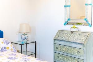 a bedroom with a dresser and a mirror on the wall at Capri Villa Vittoria by Capri Property in Anacapri