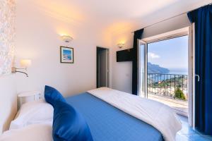 a bedroom with a bed and a window with a view at Al Borgo Torello in Ravello