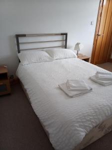 a large white bed with two white towels on it at 3 Newton Street in Bristol