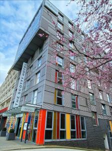 a large building with colorful windows and a tree at THE SCOTTY Hotel Hamburg in Hamburg