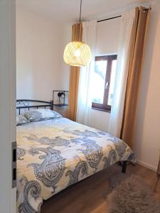 een slaapkamer met een bed, een raam en een kroonluchter bij Apartment Karlo in Sali