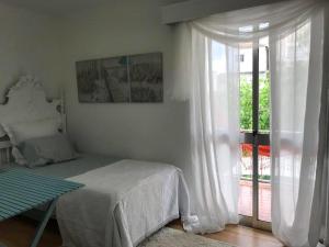 a bedroom with a bed and a sliding glass door at Margarita´s Ville in Costa Nova +9 photos