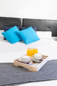 a tray with two cups and drinks on a bed at Hotel Portmán in Portman