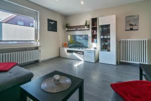 a living room with a couch a table and a tv at Ferienwohnung-Moewenblick in Norden