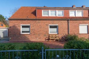 a brick house with a bench in front of it at Ferienwohnung-Moewenblick in Norden