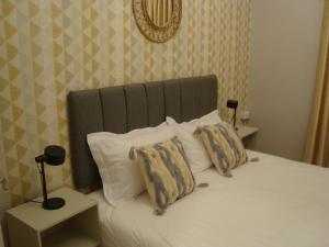 a bed with a green headboard and two pillows at Gallery Hotel in Amman