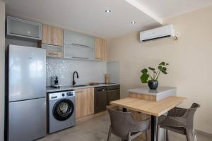 a kitchen with a refrigerator and a table with chairs at Hamaka condo a beachfront retreat on Simpson Bay Beach in Simpson Bay