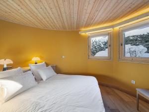 a bedroom with a white bed with a wooden ceiling at Appartement rénové avec 2 suites, balcon et poêle à bois, proche centre et remontées mécaniques, Megève - FR-1-569-39 in Megève
