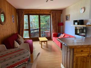 salon z czerwoną kanapą i stołem w obiekcie Bel appartement à Morzine, 2 chambres, proche centre, 6 pers, balcon, parking - FR-1-524-116 w mieście Morzine