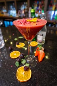 a red drink in a martini glass with fruit on a counter at Crowne Plaza - Sheffield, an IHG Hotel in Sheffield