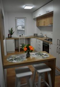 a kitchen with a table and two stools at Confort Apartament in Ploieşti