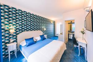 ein Schlafzimmer mit einem Bett und einer blau-weißen Wand in der Unterkunft Al Borgo Torello in Ravello
