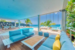 a living room with blue furniture and a view of the ocean at Surfsong Villa- Luxury Water Front Villa for 12 in Maho Reef