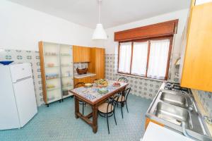 a kitchen with a table with chairs and a refrigerator at "Conchiglia" big house in the center of Maiori in Maiori