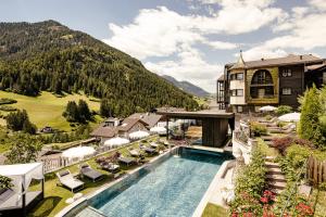 einen Luftblick auf ein Resort mit einem Pool in der Unterkunft Alpin Garden Luxury Maison & SPA - Adults Only in St. Ulrich in Gröden