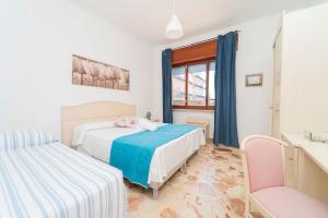 a bedroom with two beds and a chair at "Conchiglia" big house in the center of Maiori in Maiori