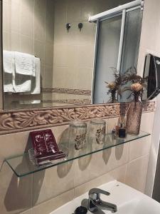 a bathroom with a glass shelf above a sink at Hostal Paulino in Trujillo +17 photos