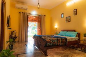 a bedroom with a bed in a room with yellow walls at Casa de Alnena in Benaulim