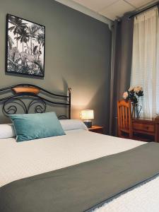 Un dormitorio con una cama con una almohada azul. en Hostal Paulino, en Trujillo