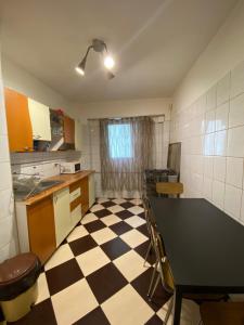 a kitchen with a black and white checkered floor at MEGA MALL National Arena APARTAMENT in Bucharest