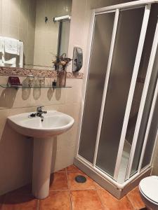 a bathroom with a shower and a sink at Hostal Paulino in Trujillo