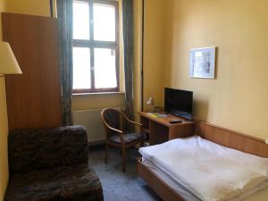 a bedroom with a bed and a desk with a computer at Gasthaus Klosterhof 