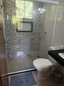 a bathroom with a shower and a toilet and a sink at Pousada Sítio da Floresta in Sana