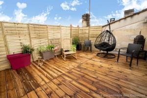 a patio with a wooden deck with chairs and a swing at La Parenthèse des Capucins - Maison d'hôtes Bordeaux in Bordeaux