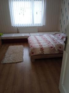 1 dormitorio con cama, ventana y alfombra en Ubytovanie Tri sestry en Hrabušice