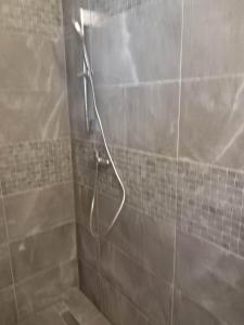 a shower with a hose in a bathroom at Ubytovanie Tri sestry in Hrabušice