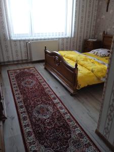 1 dormitorio con 1 cama con alfombra en el suelo en Ubytovanie Tri sestry en Hrabušice