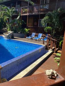 a swimming pool with two lounge chairs next to a building at Blue Bahia Resort in Sandy Bay