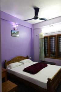 a bedroom with a bed with a ceiling fan at Ammukutty's Cottage in Munnar
