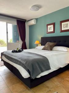 1 dormitorio con 1 cama grande y paredes azules en Finca El Otero, en Aigües