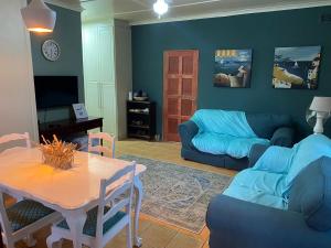 een woonkamer met een blauwe bank en een tafel bij at 22 Symmonds in Melmoth