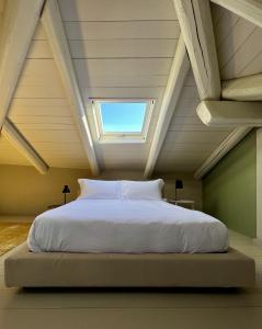 łóżko na poddaszu ze świetlikiem w obiekcie Luxury Langhe Loft w mieście La Morra