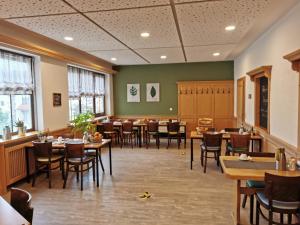 a restaurant with tables and chairs in a room at Landhotel Ölmühle in Mömbris