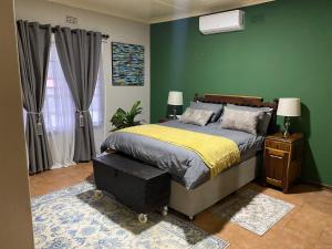 ein Schlafzimmer mit einem Bett und einer grünen Wand in der Unterkunft at 22 Symmonds in Melmoth