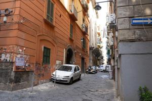 un coche blanco aparcado en una calle en un callejón en Donna Chiara Holiday House - Toledo, en Nápoles