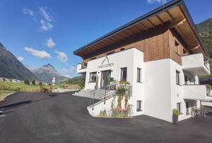 a white building with mountains in the background at Chalet Gonda inklusive Premiumcard in Galtür
