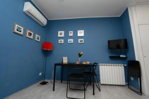 Habitación con mesa y pared azul en Donna Chiara Holiday House - Toledo, en Nápoles