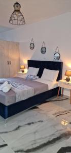 uma cama grande num quarto com duas mesas e um candeeiro em joseph apartment em Corfu Town