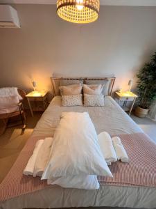 a large bed with white sheets and pillows on it at Rias Apart II in Vila Real de Santo António