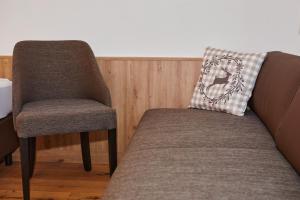 uma cadeira e uma almofada sentadas ao lado de um sofá em Das Salzburgblick em Ainring