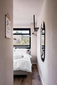 Schlafzimmer mit einem weißen Bett und einem Spiegel in der Unterkunft 4room luxury apartment, Mamilla in Jerusalem